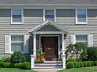 © Spiroview Inc. - Pale green two story clapboard house with shrubbery and front lawn in summer