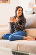 © Alvaro Montero/ADDICTIVE STOCK - Young woman with cup of coffee resting on sofa