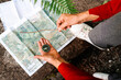 © Alberto Menendez/ADDICTIVE STOCK - From above of anonymous female tourist orientating on map and compass while standing on rock in forest
