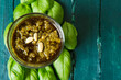 © Fatima Guisado/ADDICTIVE STOCK - Top view of small glass bowl with famous Italian pesto sauce made of fresh basil leaves and pine nuts covered with olive oil