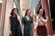 © Juan Alberto Ruiz/ADDICTIVE STOCK - Company of Asian girlfriends walking along modern building and laughing together during city stroll at night