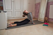 © Philippe Degroote/ADDICTIVE STOCK - Side view of skinny gymnastic girl warming up and stretching spine on mat in room