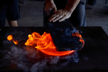 Faceless Man Working With Liquid Hot Glass While Blowing Art Elements In Dark Workshop