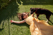 © Philippe Degroote/ADDICTIVE STOCK - High angle of happy little girl in beautiful dress lying on green grass and laughing while playing with fluffy dog during summer day in garden