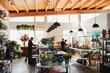© Raquel Arocena/ADDICTIVE STOCK - Unrecognizable female florists working in modern spacious light floristry store with various plants arranged in vases on shelves and hanging under ceiling