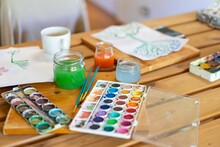 Watercolor Paints With Water And Paintbrushes On Wooden Table Home
