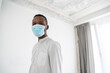 © Westend61 - Portrait of man wearing disposable face mask indoors