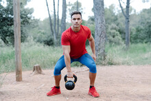 Young Athletic Man With Dumbbell In The Woods