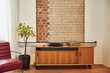 © Westend61 - Interior of a loft flat with brick wall and chest of drawers