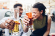 © Westend61 - Happy young couple clinking beer glasses outdoors at a bar