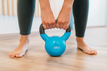 Woman's Hands Lifting Kettlebell At Gym