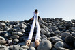 © Westend61 - Woman with artificial long hands sitting on pebbles against clear sky