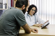© Westend61 - Smiling female doctor showing digital tablet to patient in clinic