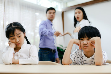 Family problems concept, father and mother quarreling in the house so causing children to feel bad.