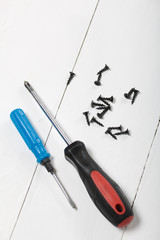 Two screwdrivers and a handful of screws. On white background.