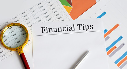 Poster - FINANCIAL TIPS Business reports, blank paper , data tables and charts,magnifier, - directly above view of office table workspace