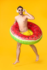 Sticker - Happy man with headphones and inflatable ring on color background