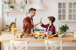 © deniskomarov - Happy father give five to loving son on kitchen