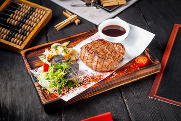 Wall Mural - Fillet mignon steak on board with salad and sauce