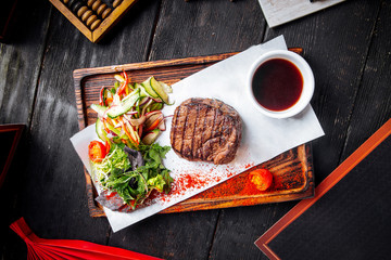 Wall Mural - Fillet mignon steak on board with salad and sauce