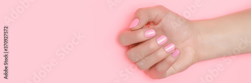 Valokuvatapetti Beautiful female hand with perfect pink nails polish on pink background