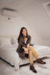 © bnenin - Portrait of casually elegant woman sitting on the bed in a modern loft.
