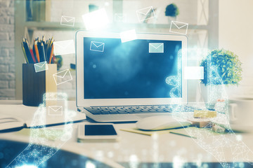 Desktop computer background in office and flying envelops hologram drawing. Double exposure. Electronic mail concept.