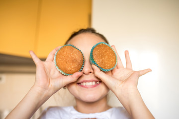 Wall Mural - little girl eating cake. young woman cooking in kitchen. chocolate chip muffins. christmas cupcake with icing