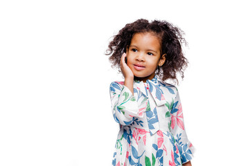 Wall Mural - Little pretty fashionable african american girl in white floral print dress looking away