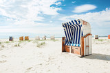 Fototapeta Krajobraz - Blue and white striped beach chair or bench