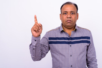 Portrait of mature overweight Indian businessman against white background