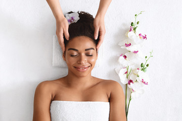 Wall Mural - Top view of joyful black woman getting head massage