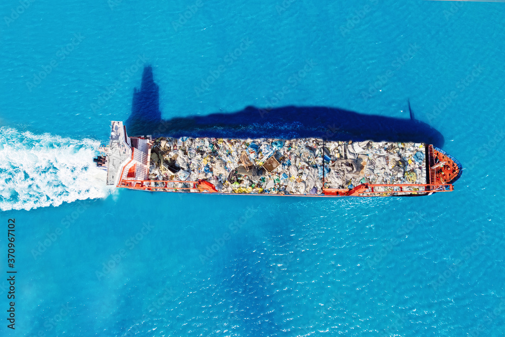 Cargo ship transports containers of garbage for recycling factory ...