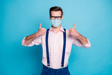 Poster - Portrait of his he attractive healthy guy wearing gauze safety mask showing double thumbup advert vaccine immunity care help assistance insurance isolated bright vivid blue color background