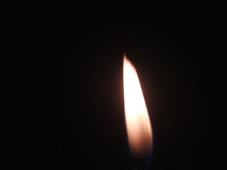 burning candle on black background