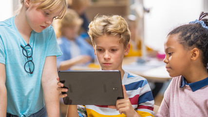 Poster - Elementary School Computer Science Class: Two Girls and Boy Use Digital Tablet Computer with Augmented Reality Software, They’re Excited, Full of Wonder, Curiosity. Children in STEM, Playing, Learning