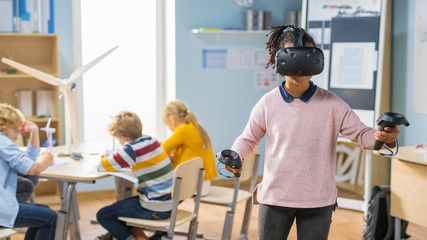 Fototapete - Elementary School Computer Science Class: Cute Girl Wearing Augmented Reality Headset and Using Controllers Learns Lessons in Virtual Reality Excited, Curious and Interested in Knowledge