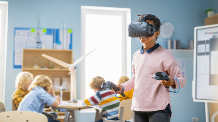 Wall Mural - Elementary School Computer Science Class: Cute Girl Wearing Augmented Reality Headset and Using Controllers Learns Lessons in Virtual Reality Excited, Curious and Interested in Knowledge