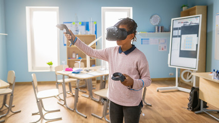 Wall Mural - Elementary School Computer Science Class: Cute Girl Wearing Augmented Reality Headset and Using Controllers Learns Lessons in Virtual Reality Excited, Curious and Interested in Knowledge