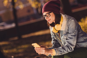 Close-up profile side view portrait of her she nice attractive pretty focused cheery girl using gadget app 5g post social network blogging smm comment sunny day October outdoor outside