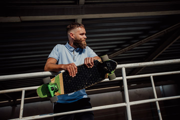 Poster - Handsome young stylish hipster guy with beard with a longboard