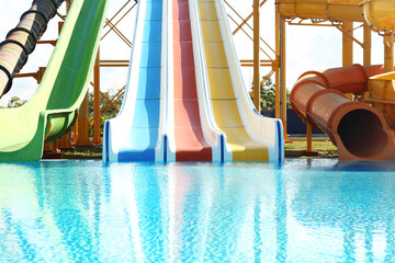 Poster - Different colorful slides and swimming pool in water park on sunny day