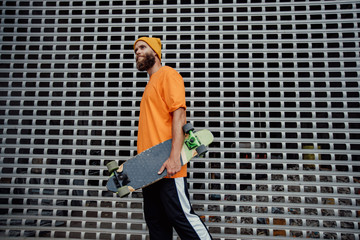 Poster - Handsome young stylish hipster guy with beard with a skateboard