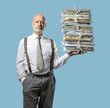 © stokkete - Confident businessman holding a pile of paperwork with one hand