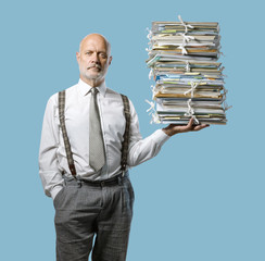 Confident businessman holding a pile of paperwork with one hand