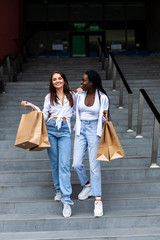 Wall Mural - Young happy multiethnic friends with shopping bags