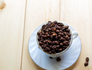 Poster - White mug with Cup of coffee beans on wooden background with selective focus and crop fragment