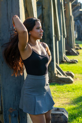 young woman sitting or standing next to a wooden and iron bridge