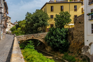 A view along the Darro river in the Albaicin district of Granada in the summertime