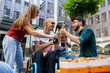 © master1305 - Bottles clinking. Group of friends taking a stroll on city's street in summer day. Handicapped man with friends having fun. Inclusion,diversity concept, normal lifestyle of special groups of society.